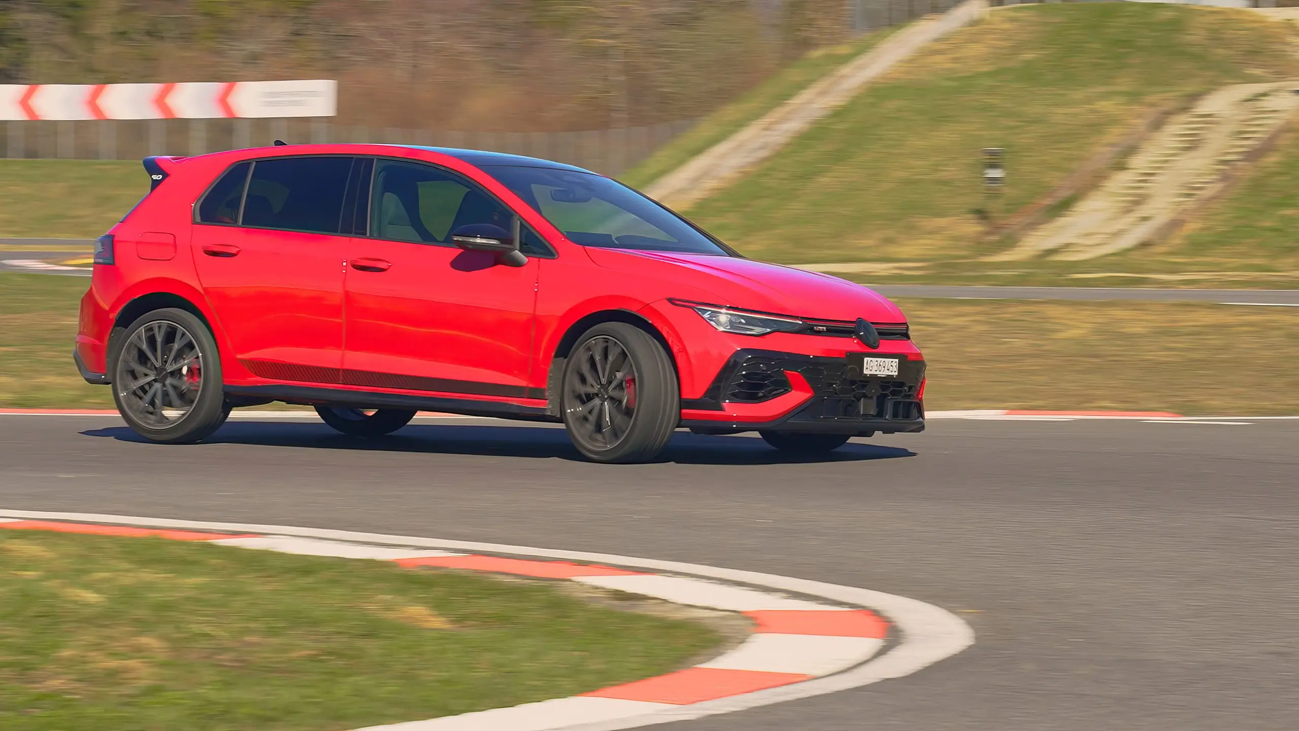 Roter VW Golf mit UHP-Reifen fährt dynamisch durch eine Kurve auf der Teststrecke.