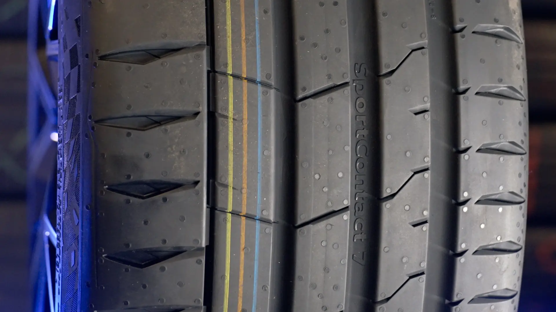 Nahaufnahme des Continental SportContact 7 mit breiten Profilrillen und farbigen Markierungslinien