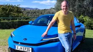 Sämi Pfister lehnt an einem blauen Honda Prelude vor grüner Hügellandschaft