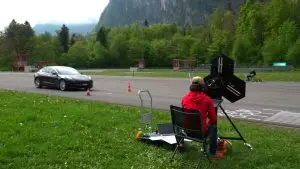 Messung des Verkehrslärms: Auto fährt an Mikrofonen und Testgerät am Strassenrand vorbei.