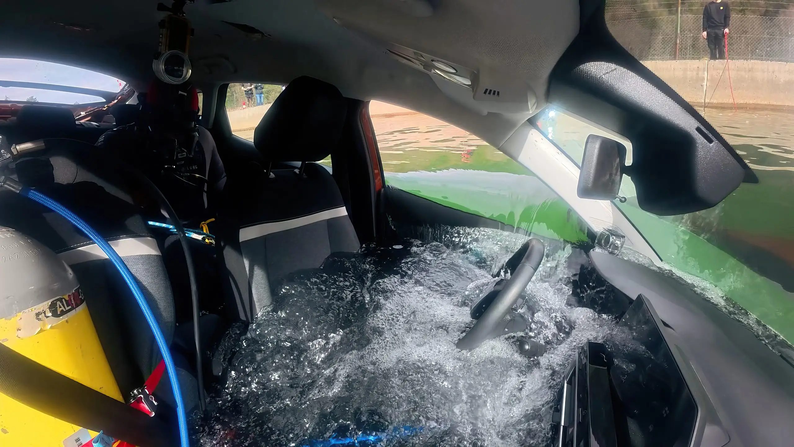 Wasser flutet den Innenraum eines Testautos; Lenkrad und Sitze stehen bereits unter Wasser.