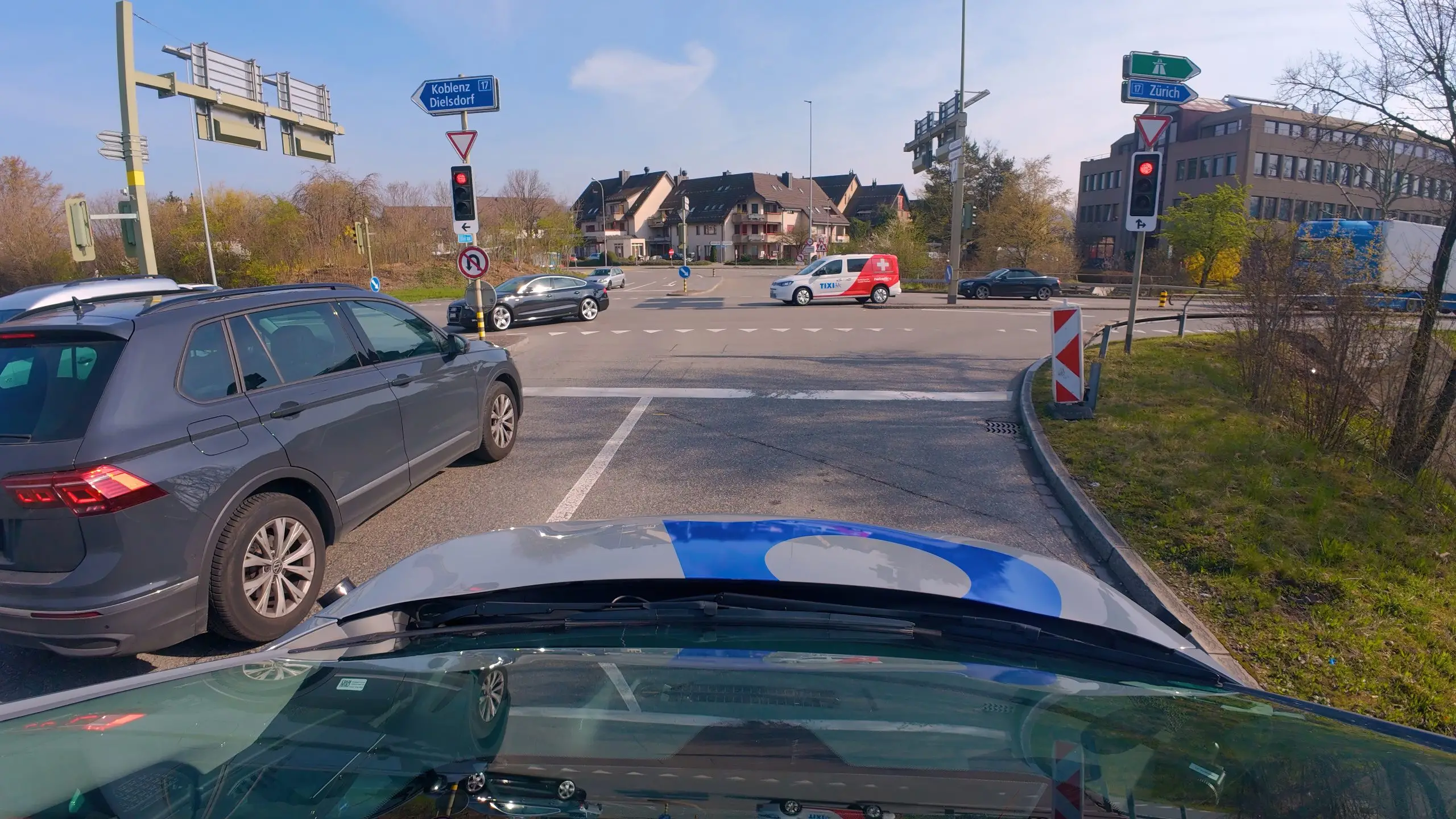 Autonomes Testauto wartet an roter Ampel deutlich vor der Haltelinie im Verkehr von Regensdorf.