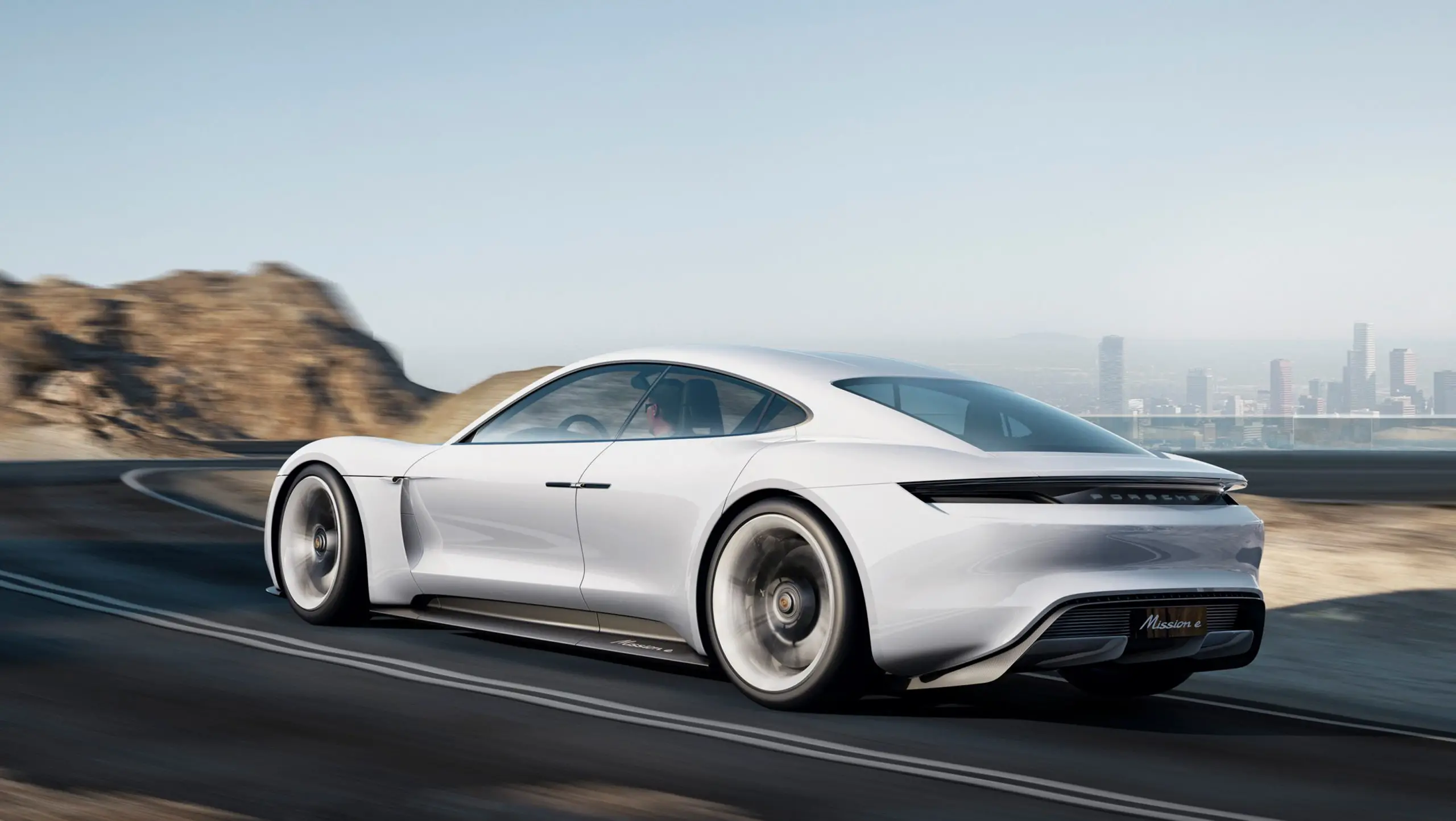 Weisse Studie Porsche Mission E auf einer Küstenstrasse