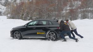 Zwei Autos mit Sommer- und Winterreifen bei einem Reifentest auf Schnee.