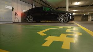 Elektroauto beim Laden an einer Wallbox in der Tiefgarage eines Mehrfamilienhauses.