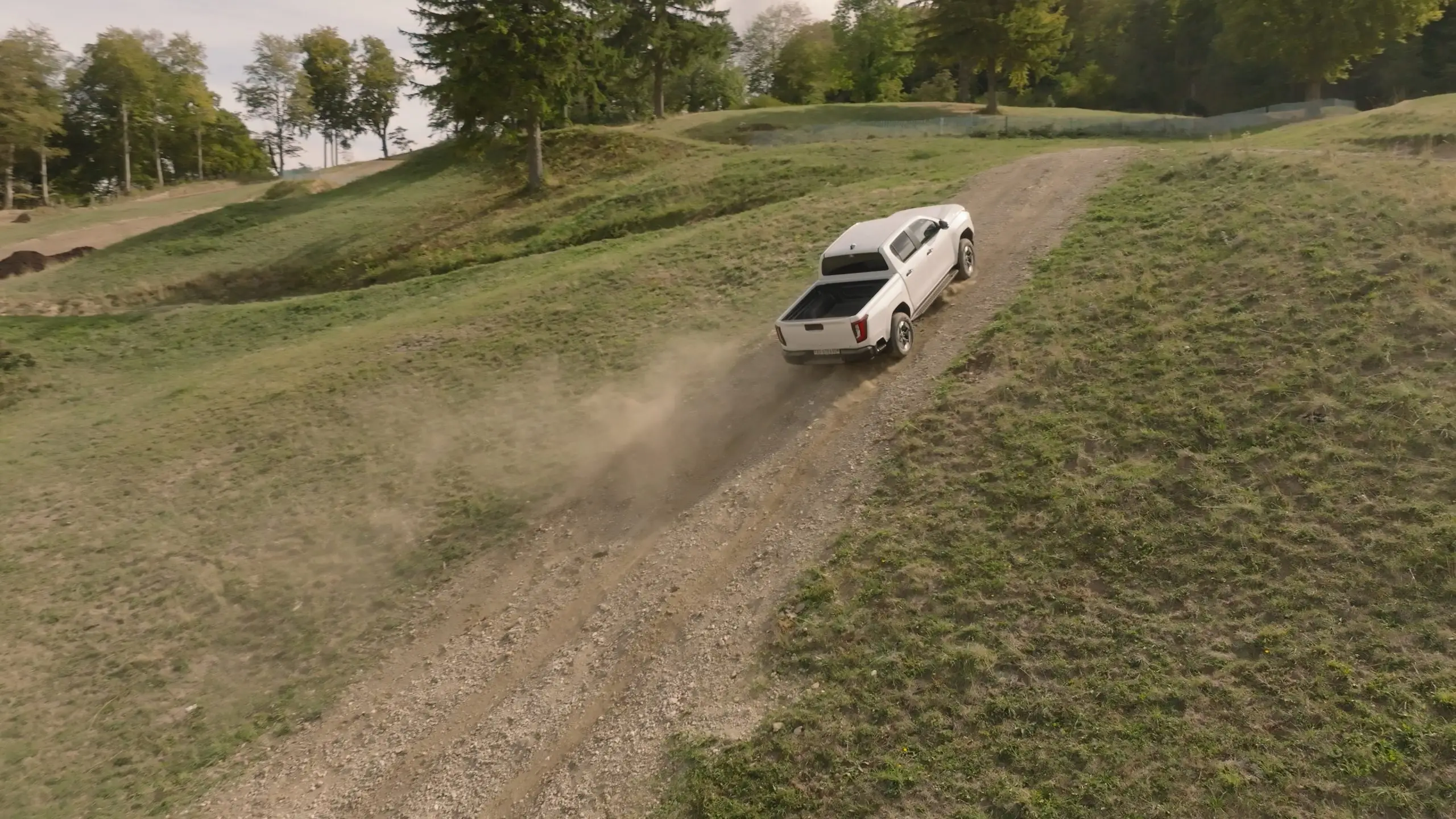 Toyota Hilux Elektro fährt eine steile, staubige Schotterpiste hinauf.