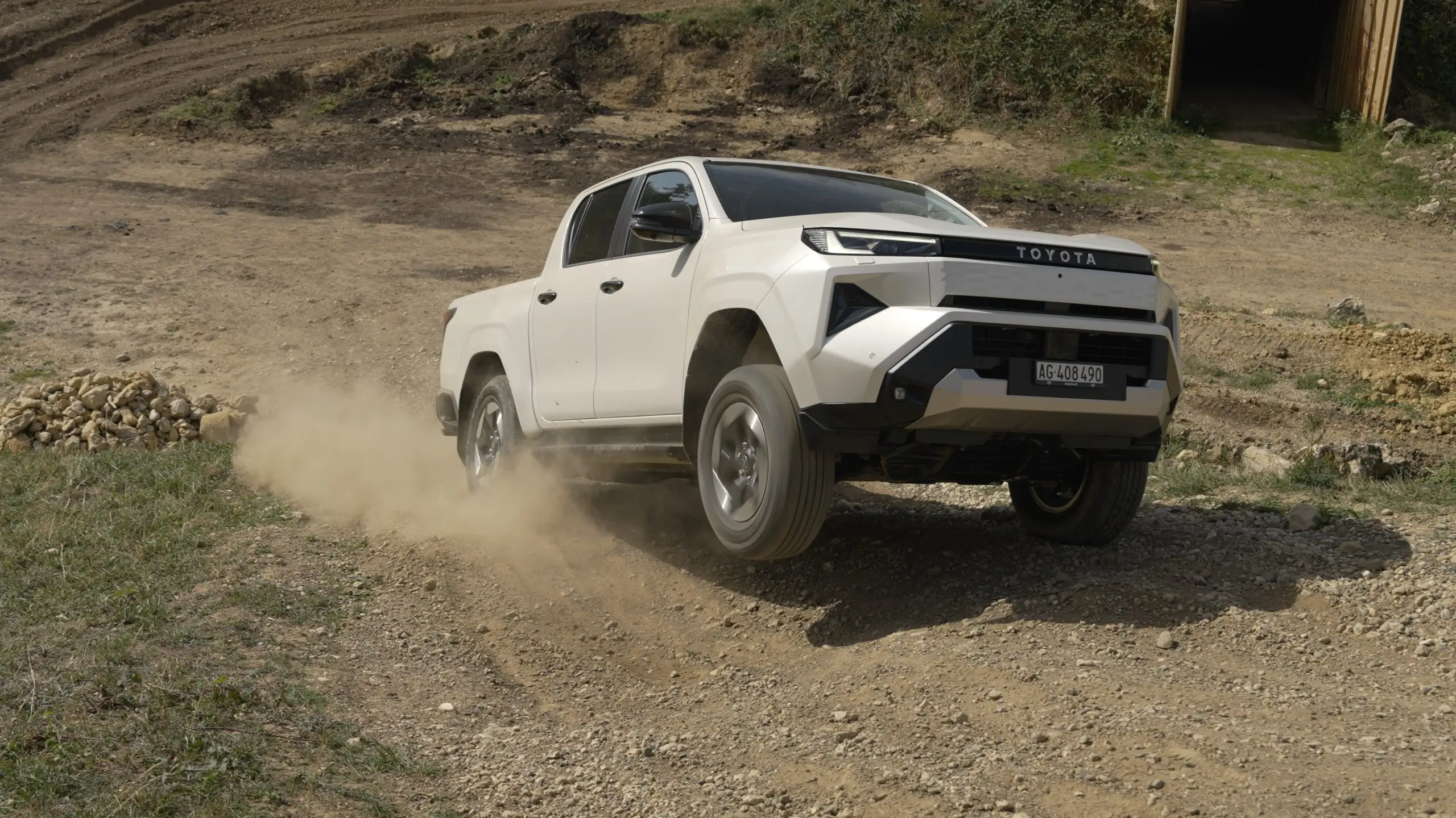 Toyota Hilux Elektro überquert eine tiefe Bodenrinne mit stark verschränkten Achsen.